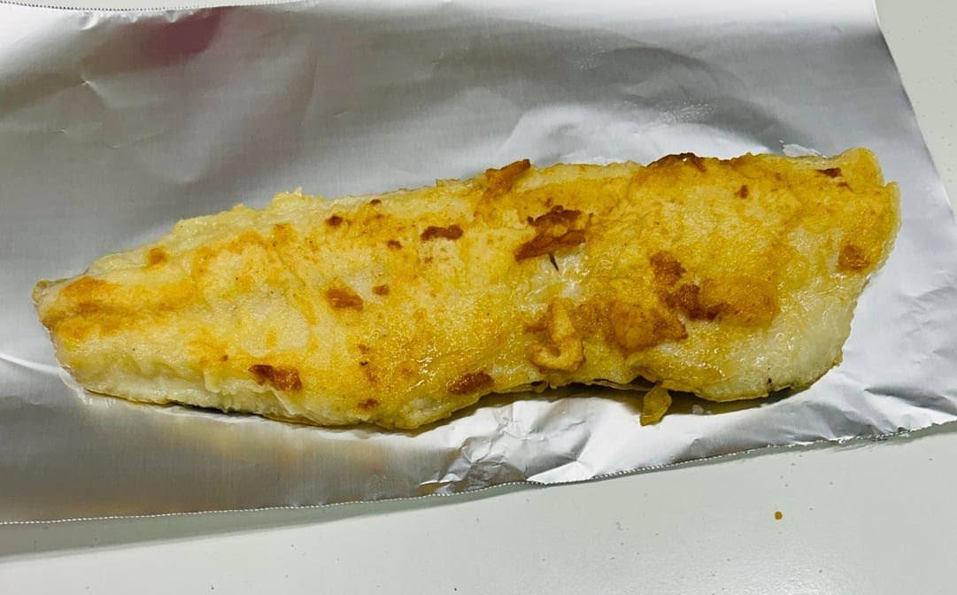 Battered fish on white paper